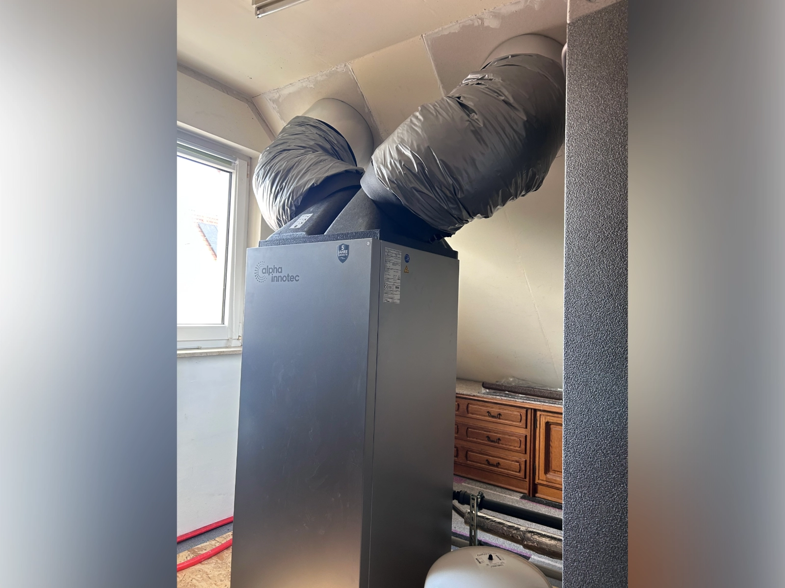 Innenansicht der Wärmepumpenanlage mit Luftkanälen im Dachgeschoss des Wohnhauses.