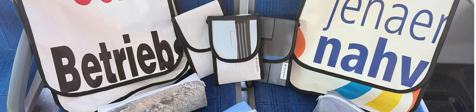 Verschiedene Taschen auf Sitzen in einem Bus.