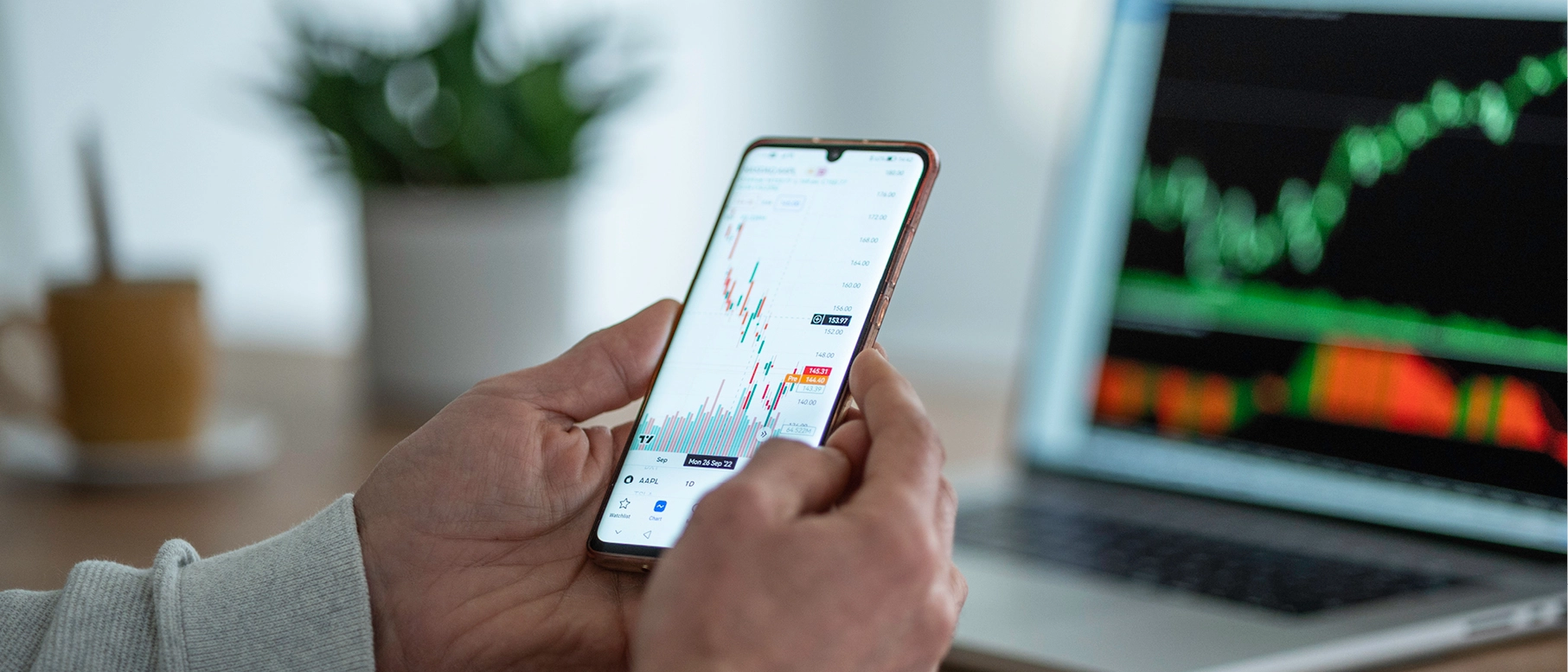 Handy und Monitor mit graphischen Daten