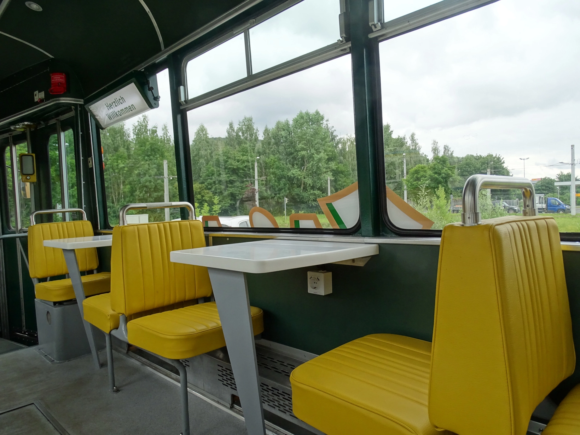 Eine Innenaufnahme der Ur-Krostitzer Partybahn. Zu sehen sind gelbe Sitze und weiße Tische.