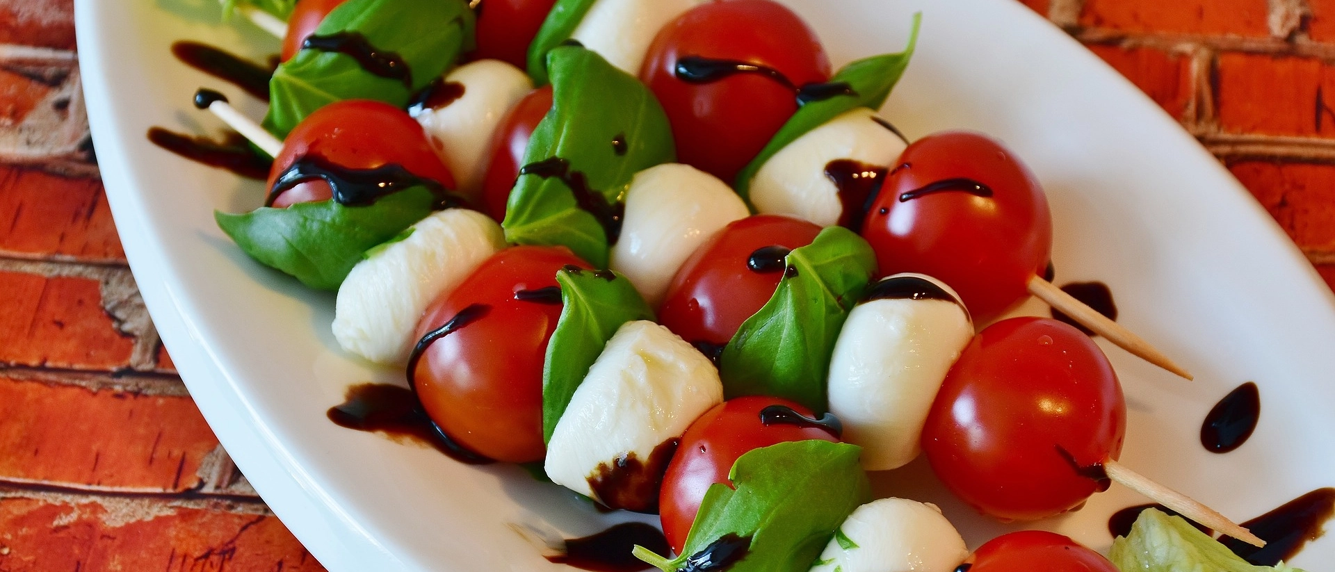 Ein Beispielbild für Tomate-Mozzarella-Spieße auf einem Teller.