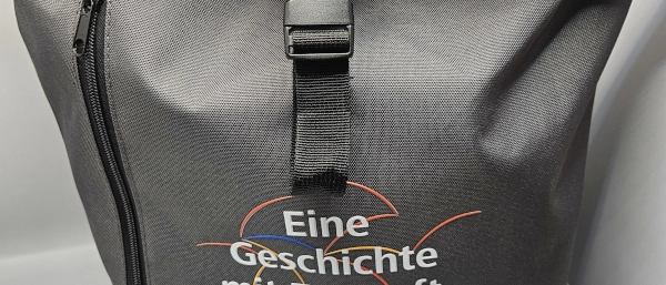 Ein grauer Rucksack im JNV-Design. 