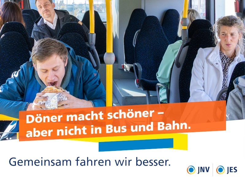 Ein Mann sitzt im Bus und isst einen Döner. Rundherum sitzen Fahrgäste und schauen zu dem Mann.